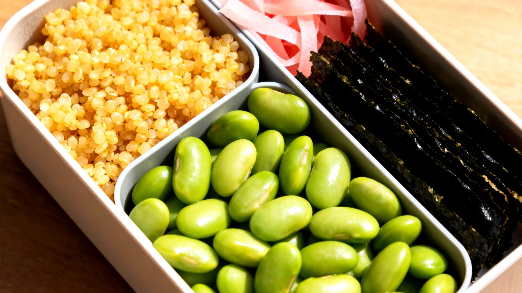 Bento-Box mit Hirse, Edamame, eingelegtem Ingwer und Nori-Algen"