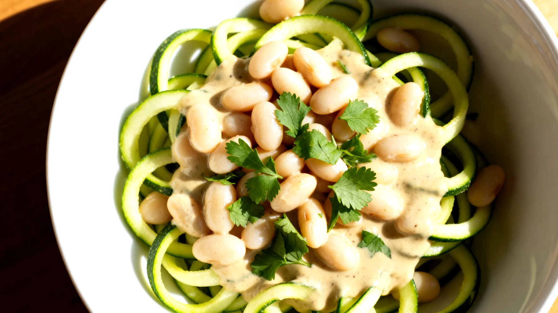 Zucchini-Nudeln (Zoodles) mit weißen Bohnen und Tahini-Sauce"